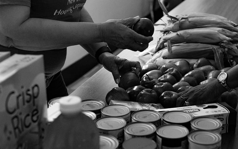 A housing worker hands out apples to residents